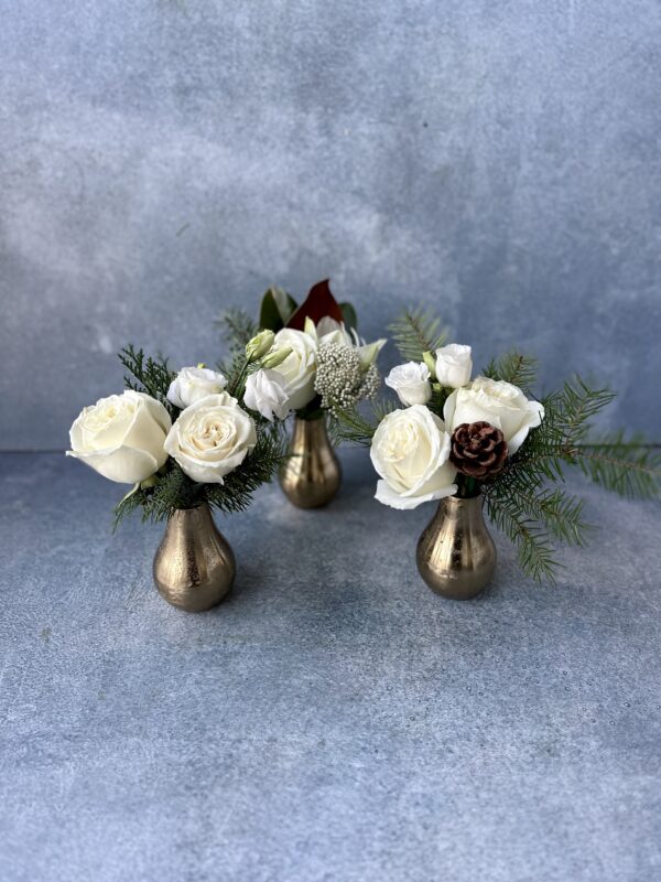 Trio of gold bud vases with white flowers, pinecones and greenery